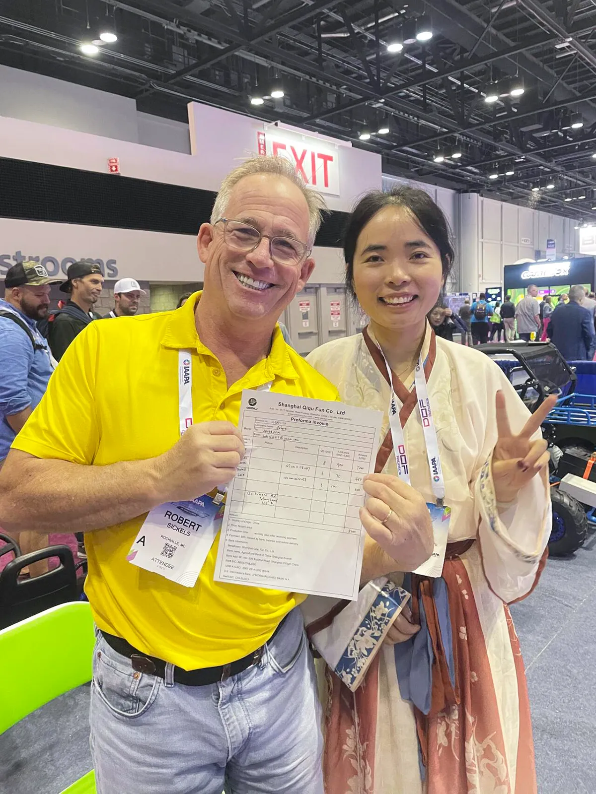 North American park operator holding signed proforma invoice for commercial bumper boat fleet at Shanghai Qiqu Fun booth, IAAPA Expo Orlando 2023