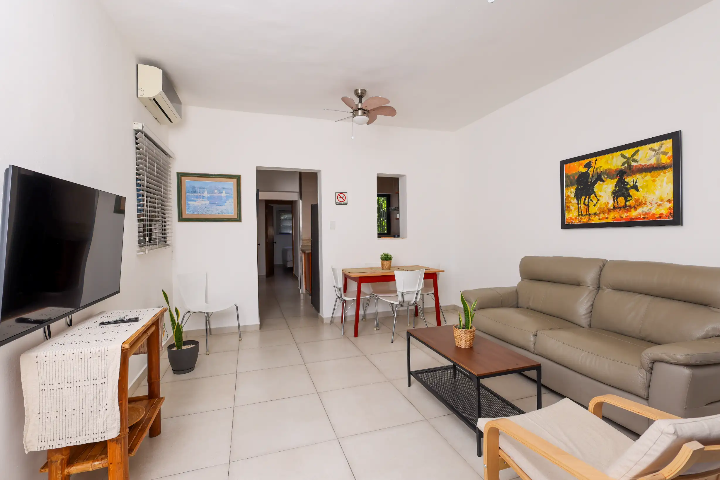 Apartment for rent in Santo Domingo Zona Colonial — living room with grey leather sofa, private balcony and Colonial District view — Unidad 1A