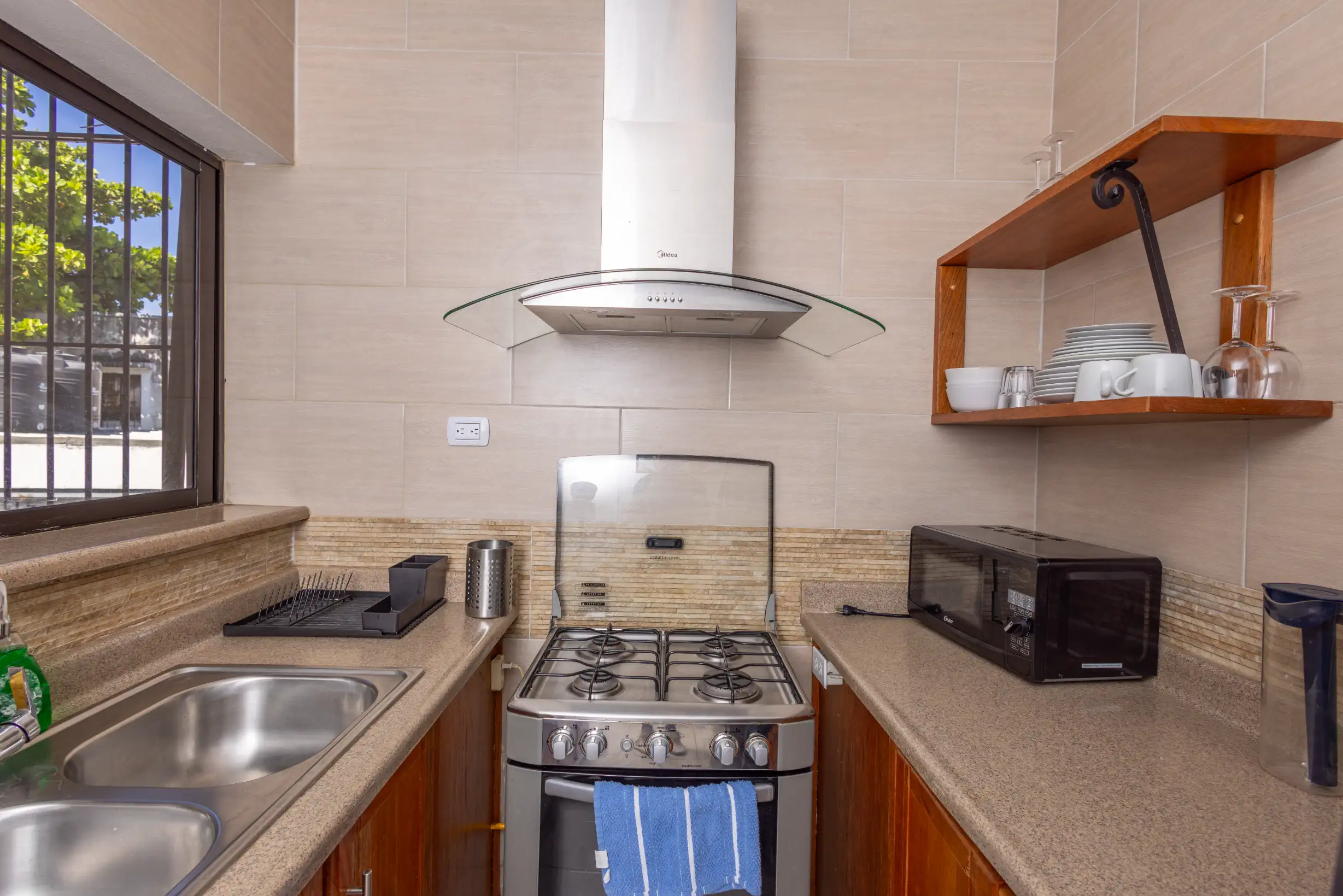 Kitchen detail: four-burner gas stove and stainless steel hood — Unidad 3B