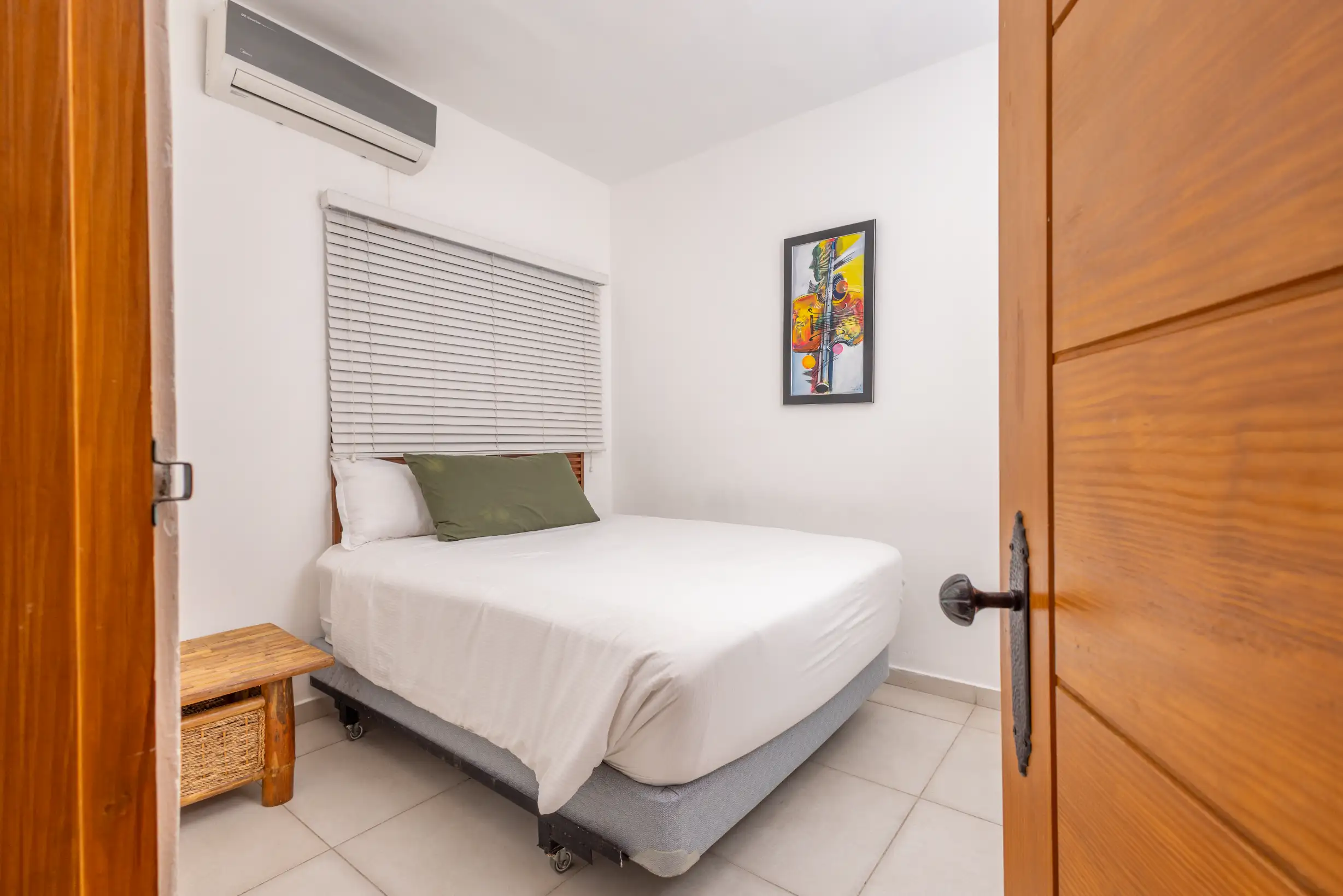 Bedroom with queen bed, air conditioning and musical-themed artwork — Unidad 3B