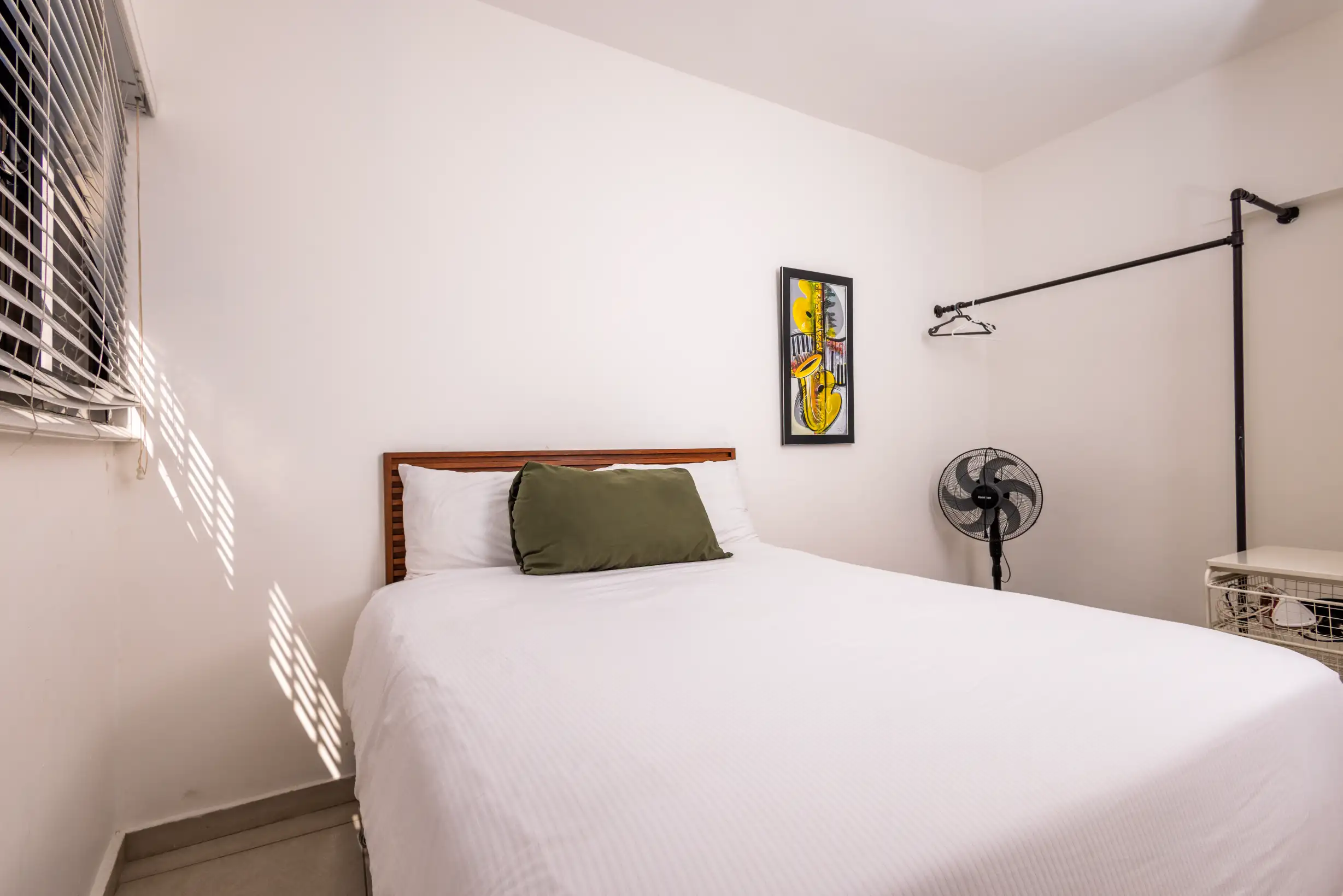 Sun-lit bedroom with queen bed and musical artwork — Unidad 3B