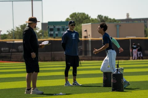 Coaches evaluating a player's throwing drill on the field