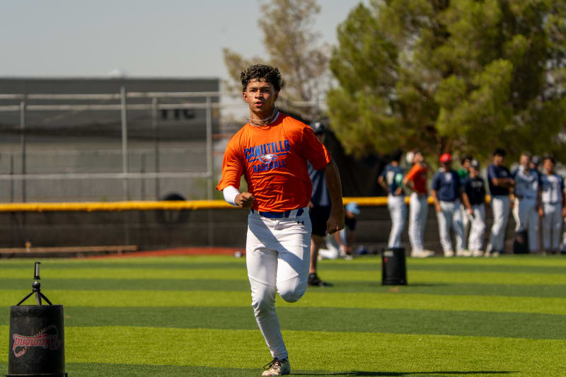 A player in an orange jersey sprinting during an on-field evaluation