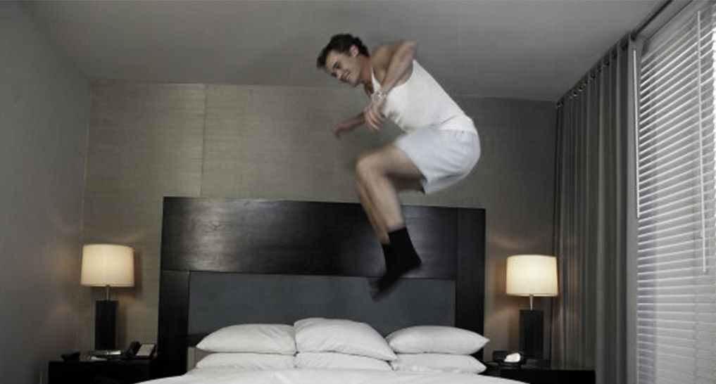 Man jumping on a bed