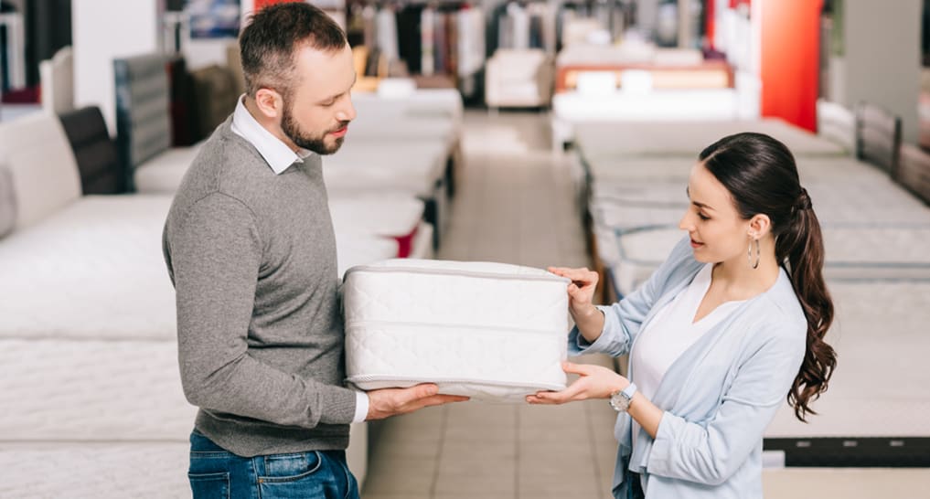 What is an Eco-friendly Mattress? A saleswoman showing a sample block of eco-friendly mattress to a customer