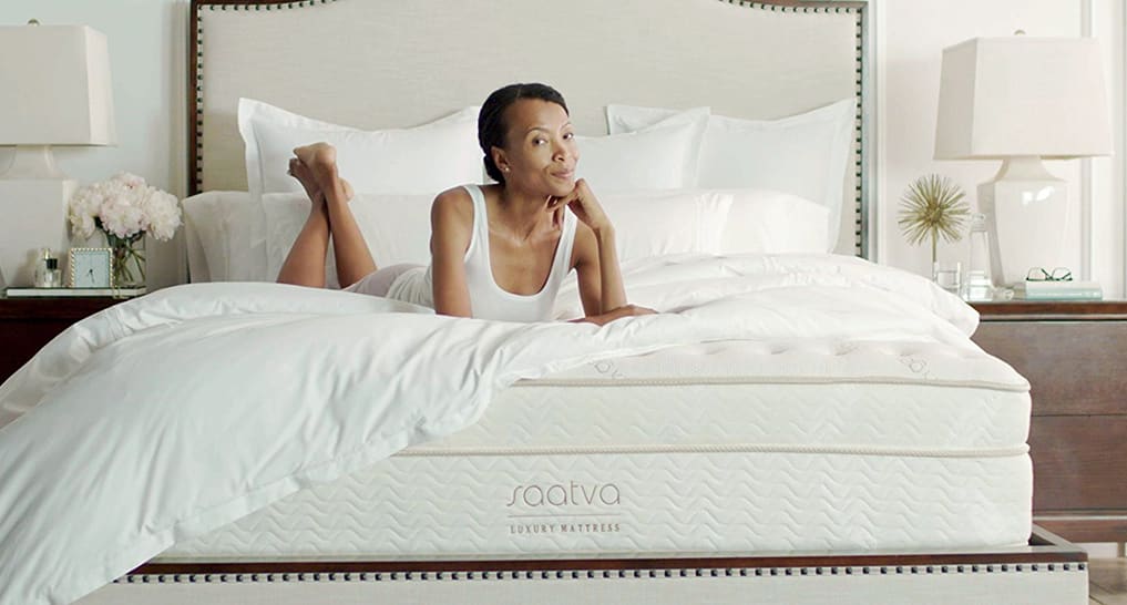 Saatva Classic Mattress A lady relaxing on Saatva Classic luxury innerspring mattress.