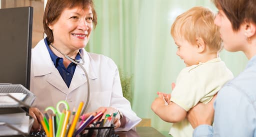 A doctor having a session with a bay and her mother. Achieve with Carolina offers different consulting packages like one-on-one packages, sessions and your child sleep manual