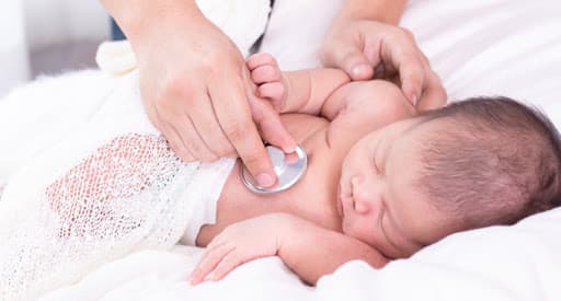 A sleeping baby being checked by a doctor. In NYC Sleep Doctor, adults are children gets treatment of behavioral sleep disorders 