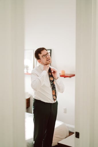 Hans tying his necktie.