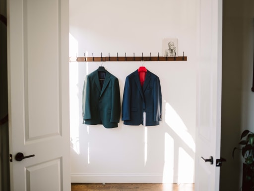 The grooms jackets hanging up in the dressing room.