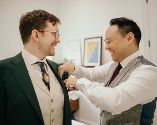 Jeremy helps Hans straighten his pocket square.