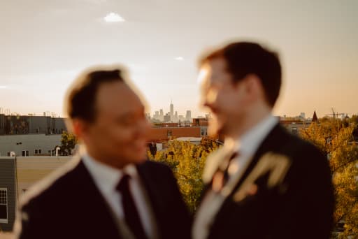 Hans and Jeremy on the rooftop with the city skyline in focus.