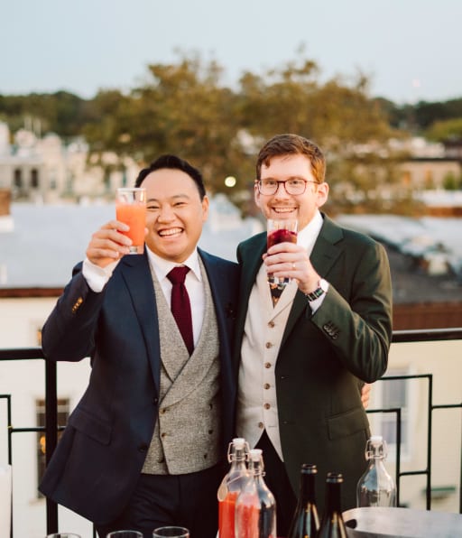 Jeremy and Hans hold up their cocktail glasses for a toast.