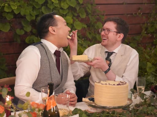 Hans feeds Jeremy a bite of cake.