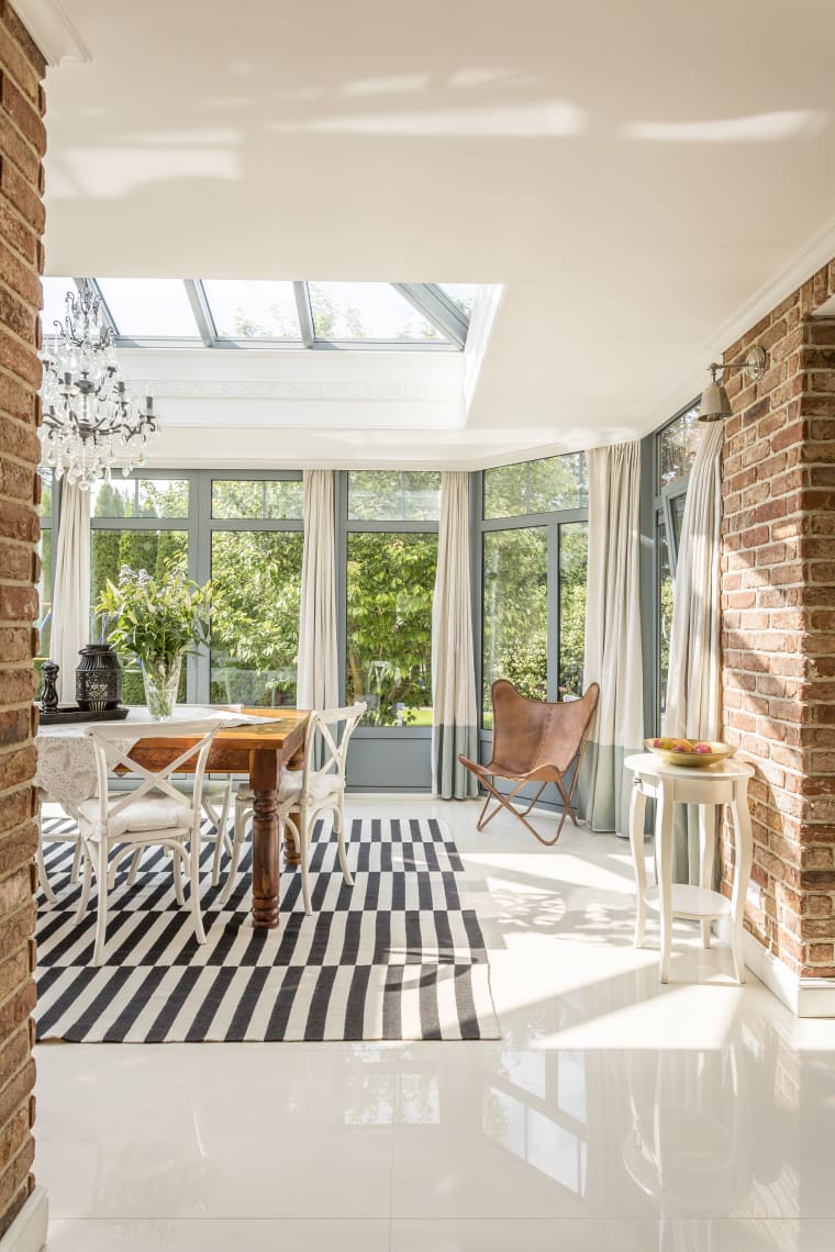 Bright conservatory dining room with skylights and full-height windows