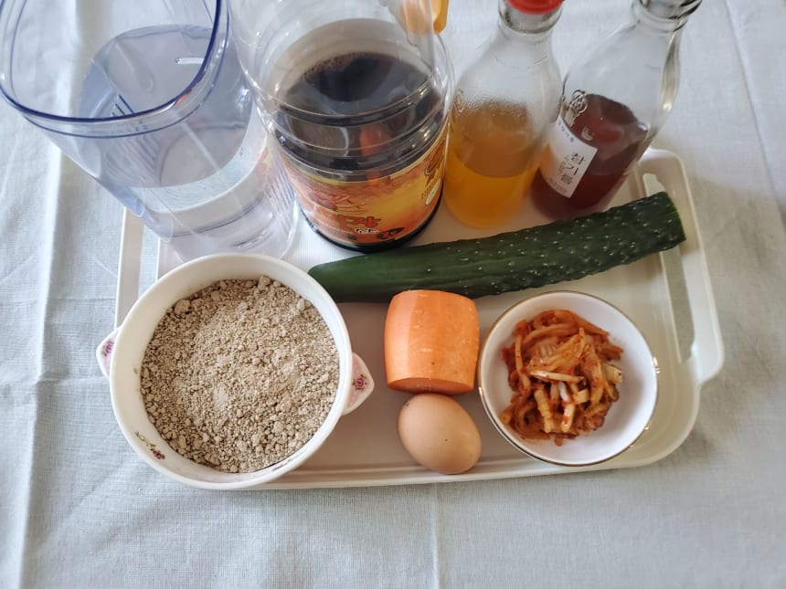 쟁반 위의 도토리가루와 오이, 당근, 달걀, 신김치, 양념