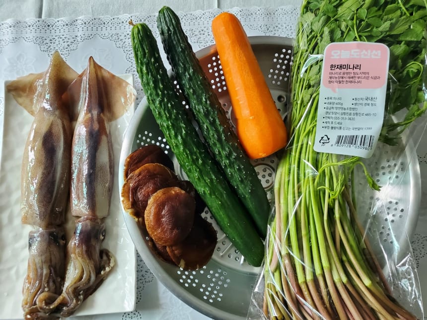 쟁반에 놓인 오징어 두 마리와 오이·당근·표고버섯·미나리