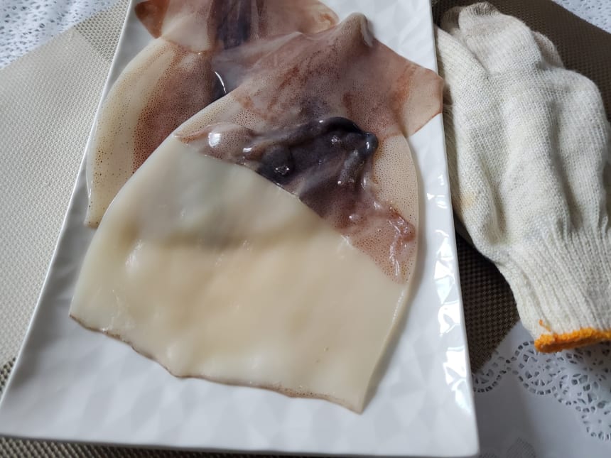 껍질을 벗기는 오징어 몸통과 면장갑