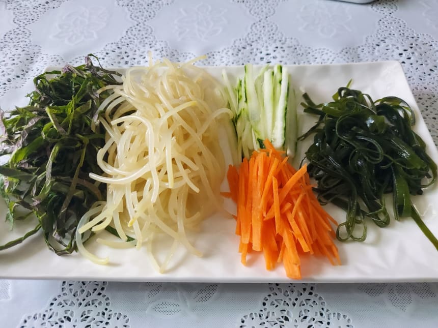 접시에 나란히 놓은 깻잎채·콩나물·오이채·당근채·다시마채
