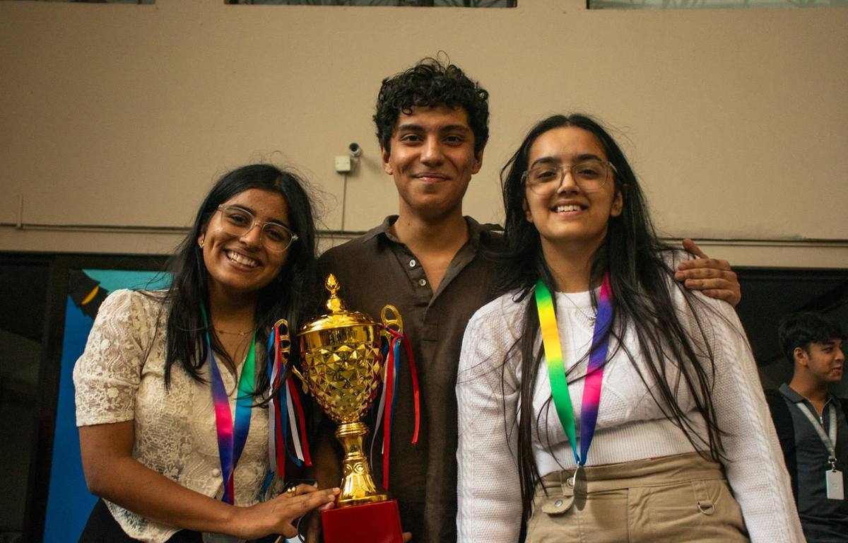 Students celebrating with debate trophy
