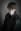 This is a portrait of a person, wearing a black leather jacket with a poppy on it and dark makeup, set against a gray background. The subject is looking directly at the viewer. blurred out low res
