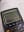 A close-up photograph of a TI-83 Plus calculator displaying a math problem. The image captures the calculator's screen and buttons alongside printed equations. blurred out low res