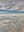 An aerial view of a mountain range covered in snow and mist, under a dramatic cloudy sky. The scene captures the vastness and serenity of nature. blurred out low res