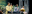 This image captures a stage performance with several actors in period costumes. The composition highlights a moment of drama during the play. blurred out low res