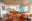 An interior shot of a modern living space, featuring a kitchen, dining area, and living room. The scene is illuminated by natural light. blurred out low res