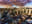 An aerial view of a cityscape at sunset, with dramatic clouds overhead. The image captures the urban landscape with a warm, golden light. blurred out low res