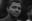 A black and white portrait of a man, showcasing a close-up of his face and expression. The image captures a mood of introspection. blurred out low res