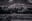 A serene monochrome landscape featuring traditional Japanese architecture nestled among lush greenery. Overhead power lines add a modern touch to the otherwise timeless scene. blurred out low res