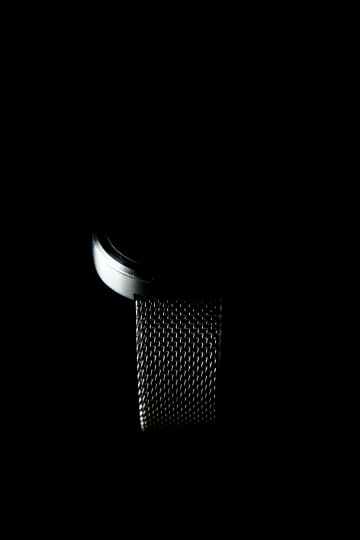 A close view of a silver mesh band against black.