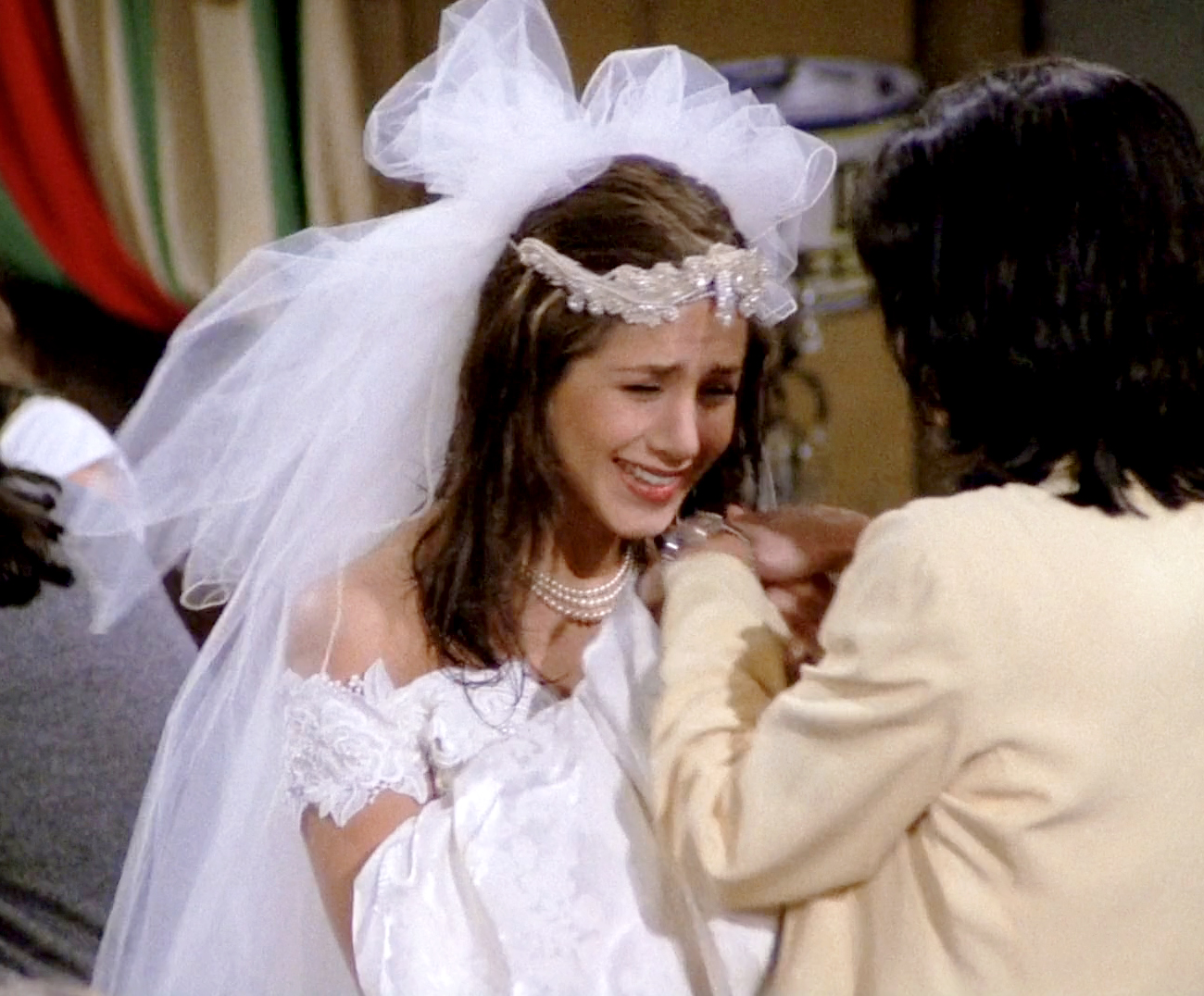 Close-up of Rachel's runaway bride look—lace wedding dress, tulle veil, and pearl choker