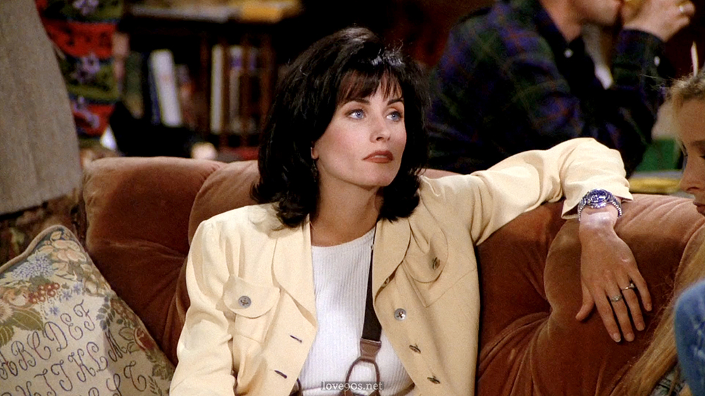 Monica in pale yellow jacket and white ribbed tee at Central Perk, Friends S1E1