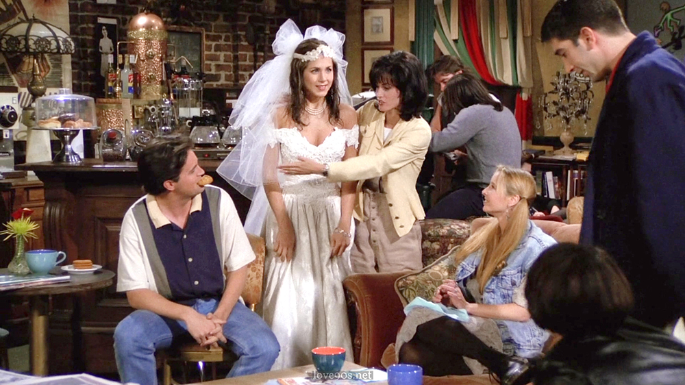 Monica in pale yellow jacket and white ribbed tee at Central Perk, Friends S1E1