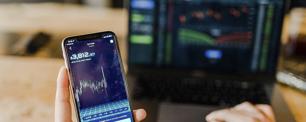 Broker mirando el móvil y ordenador