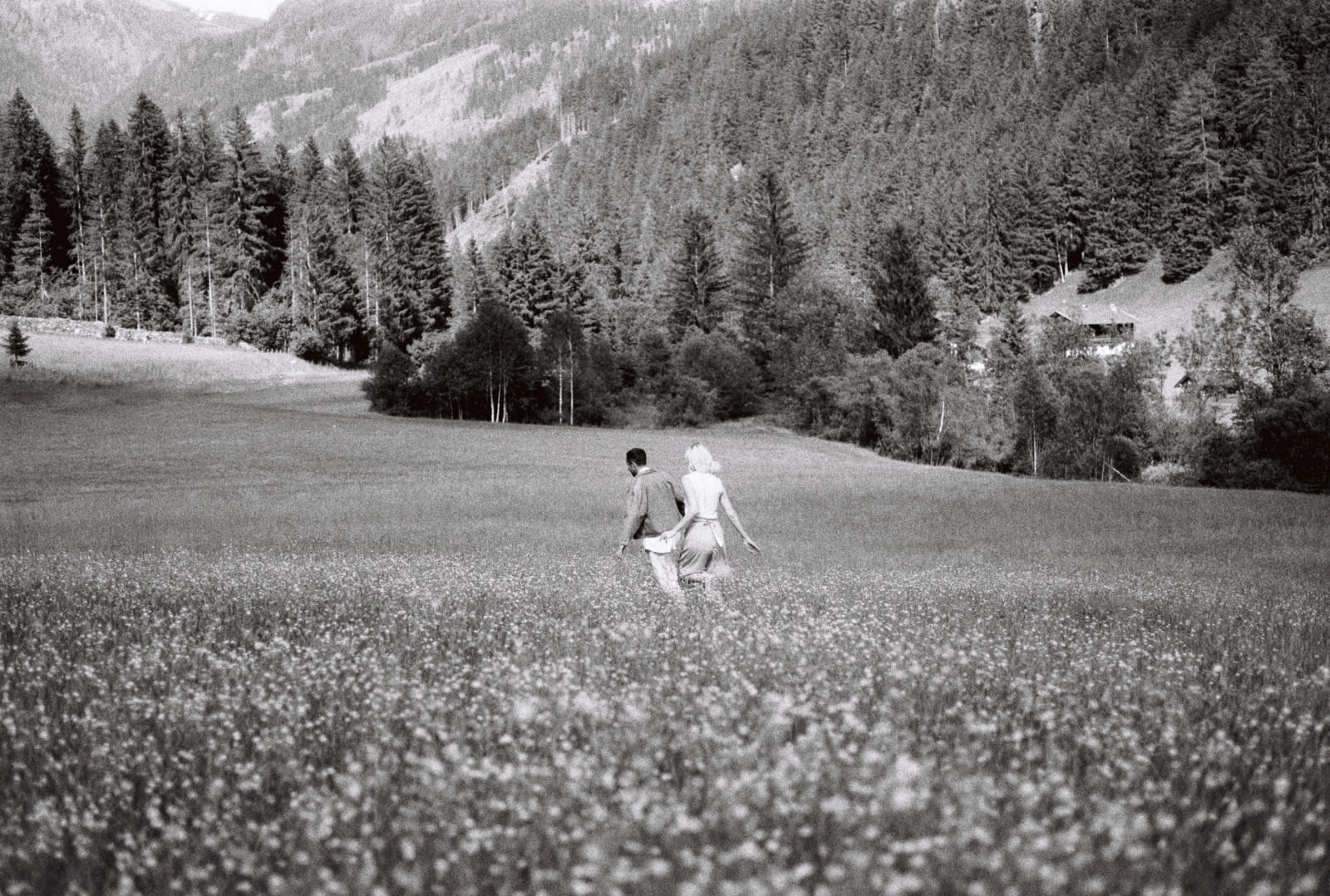 A couple walking through a mountain meadow