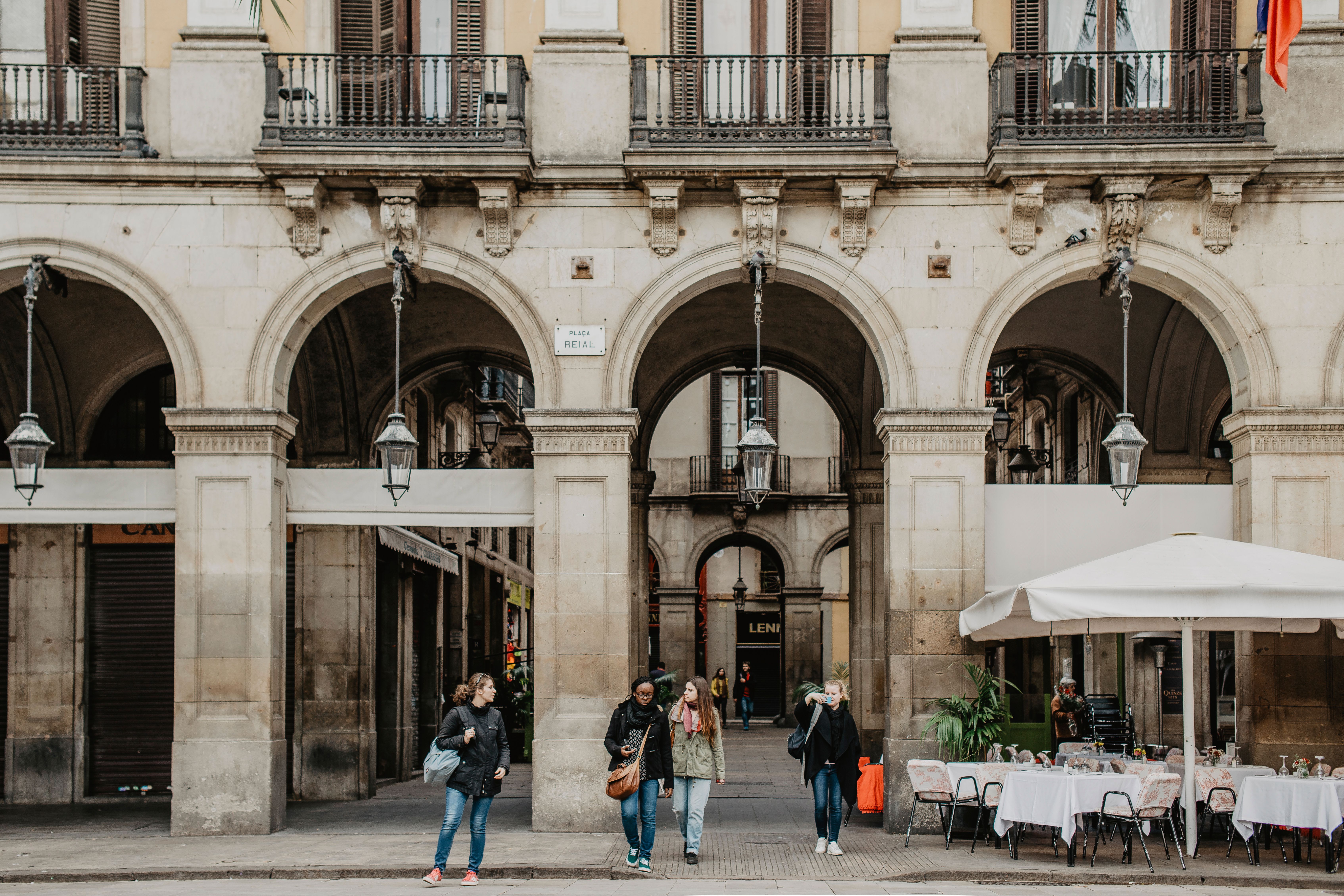 A lively Gràcia plaça with cafe terraces and locals, village atmosphere