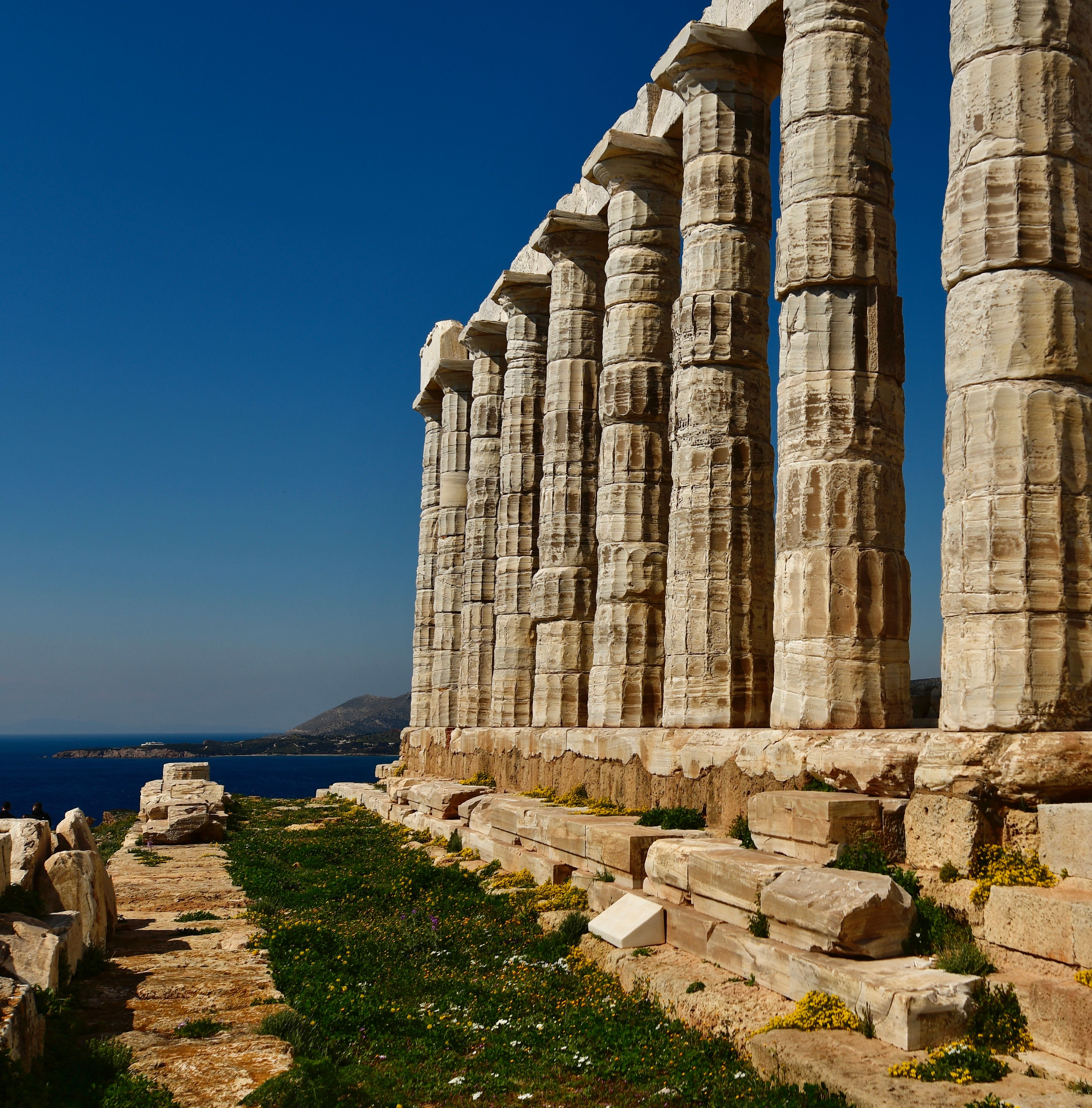 The Temple of Poseidon at Cape Sounion on its clifftop above the blue Aegean