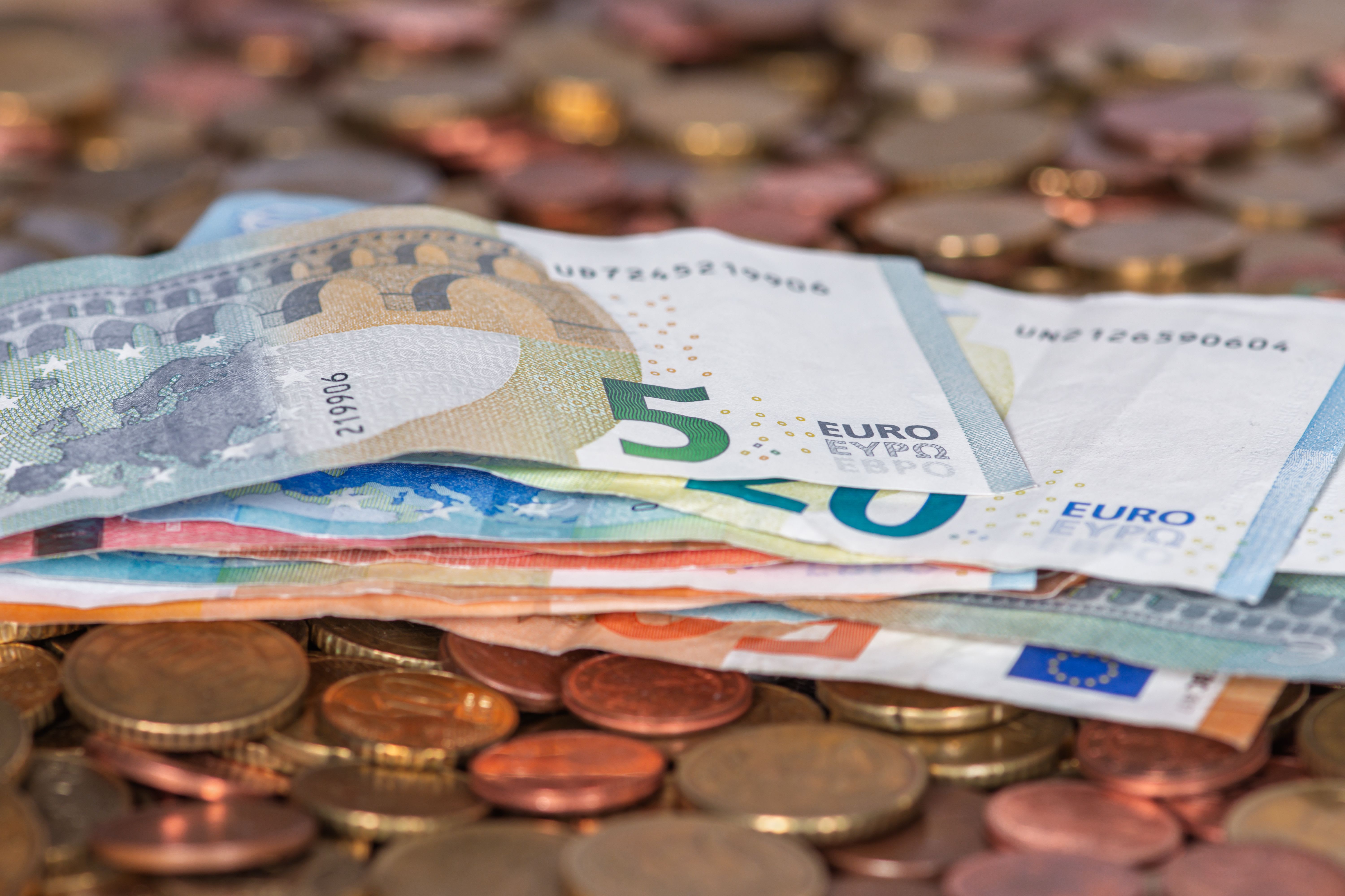 Euro banknotes and coins, or a card payment at a Greek café