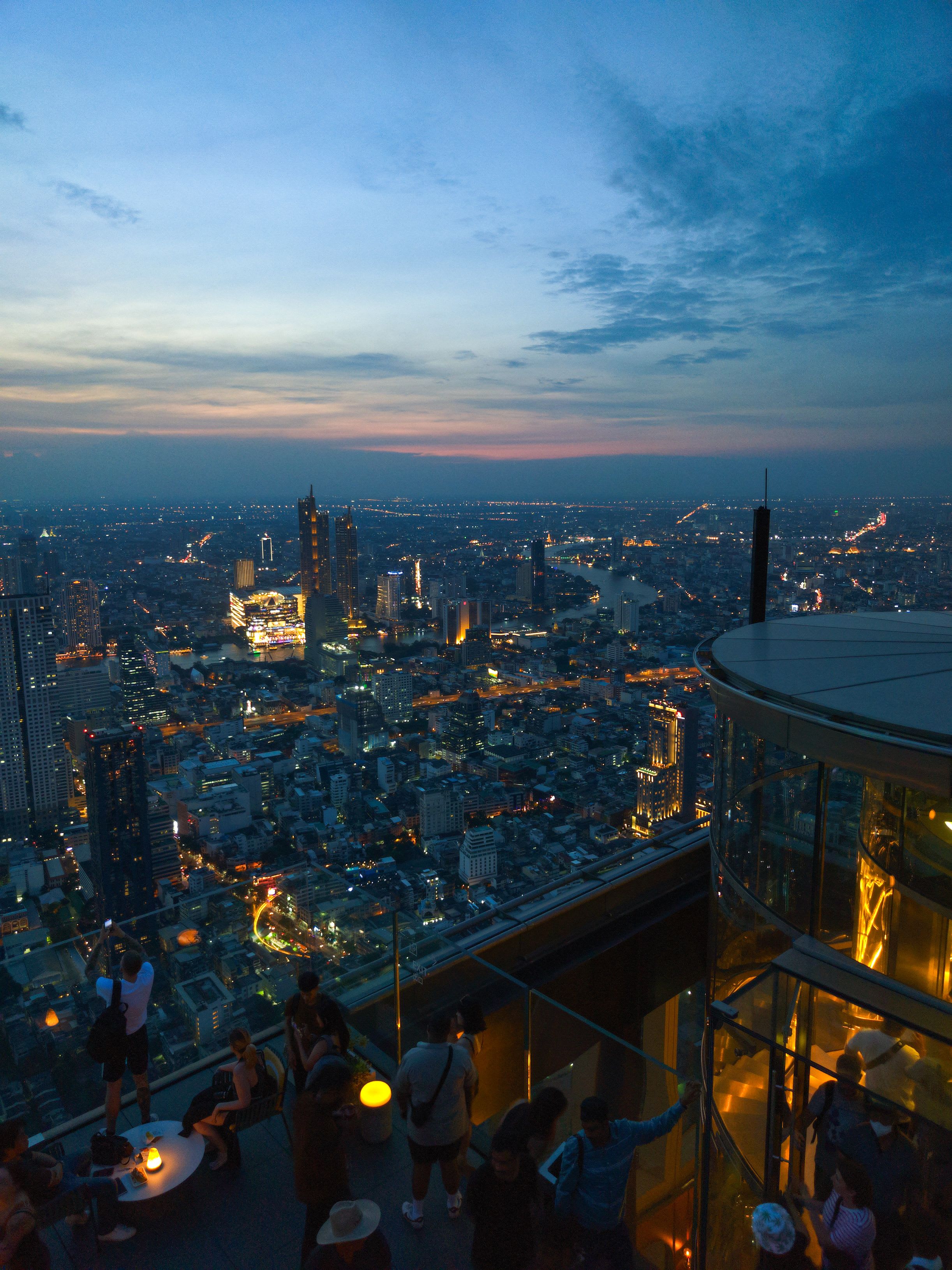 A Bangkok rooftop bar or infinity pool overlooking the glittering skyline at dusk