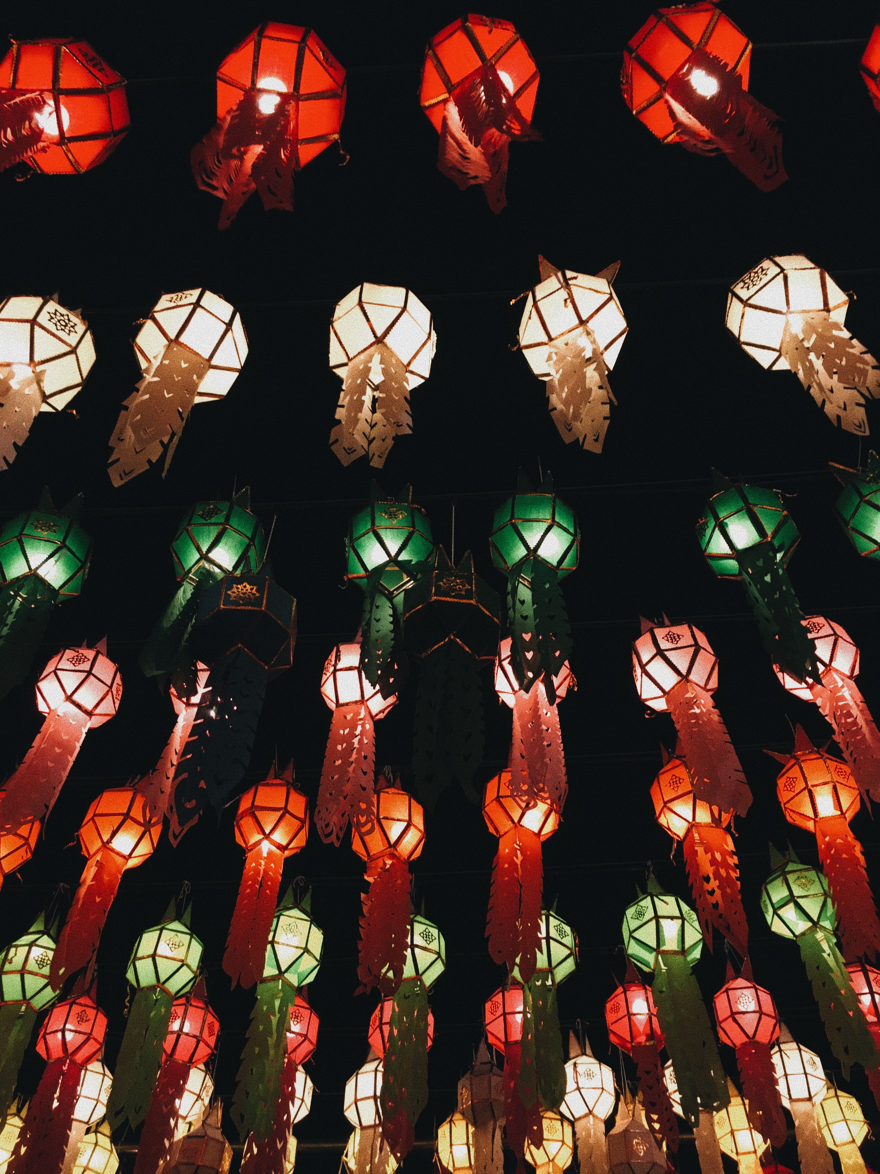 Sky lanterns rising into the night during Yi Peng in Chiang Mai