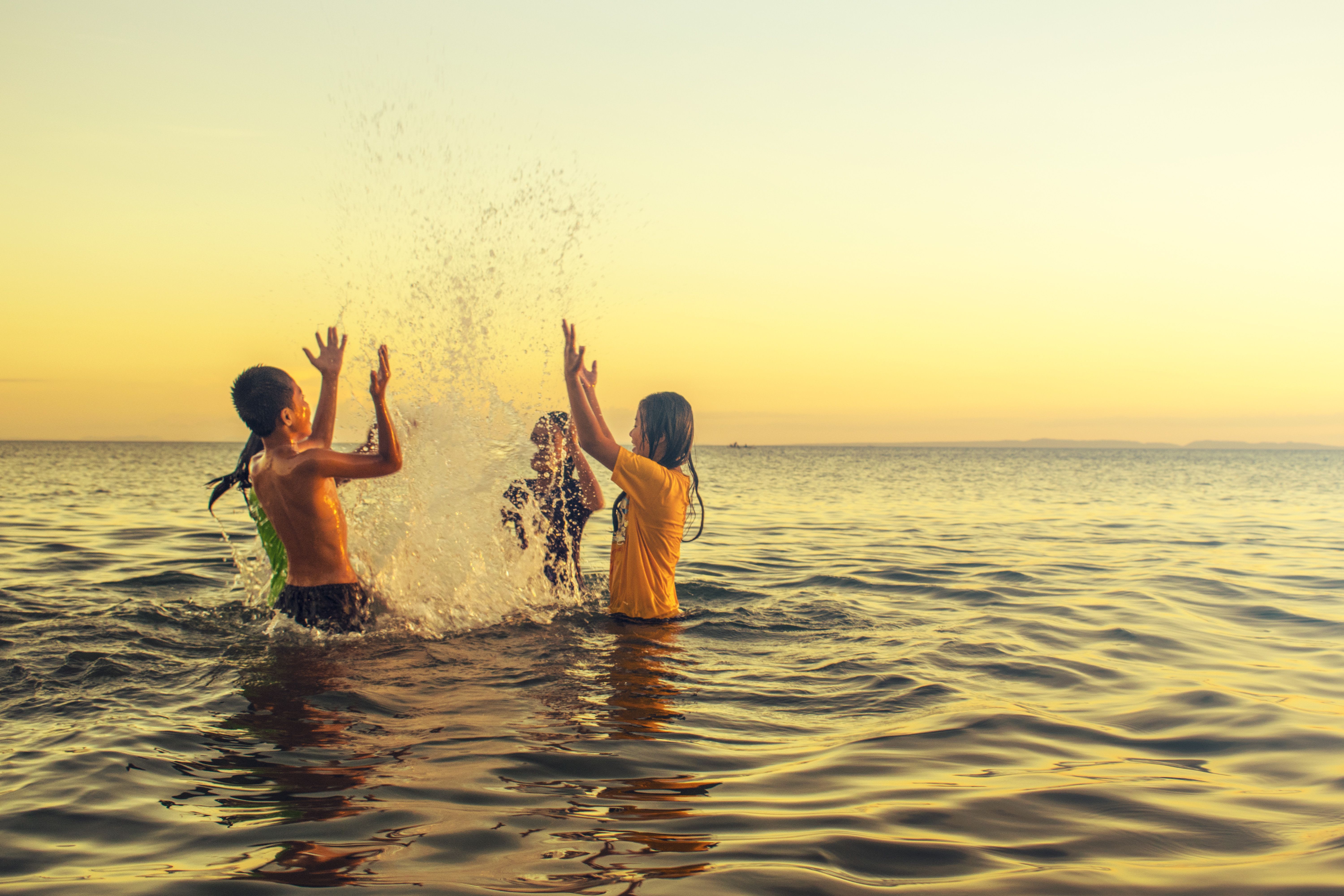 Children playing on a calm, shallow Thai beach
