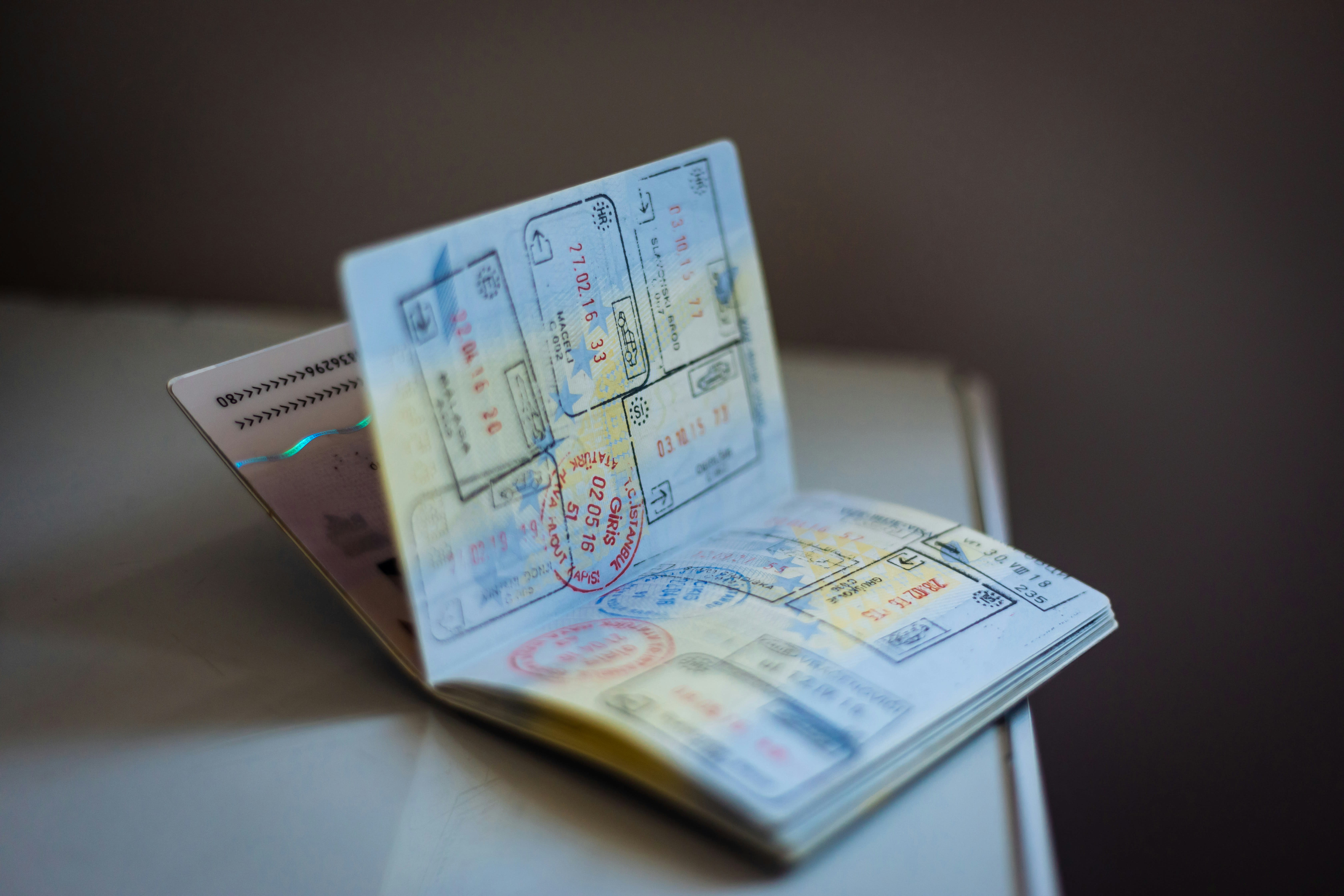 A traveler checking a passport expiration date, planning documents on a desk