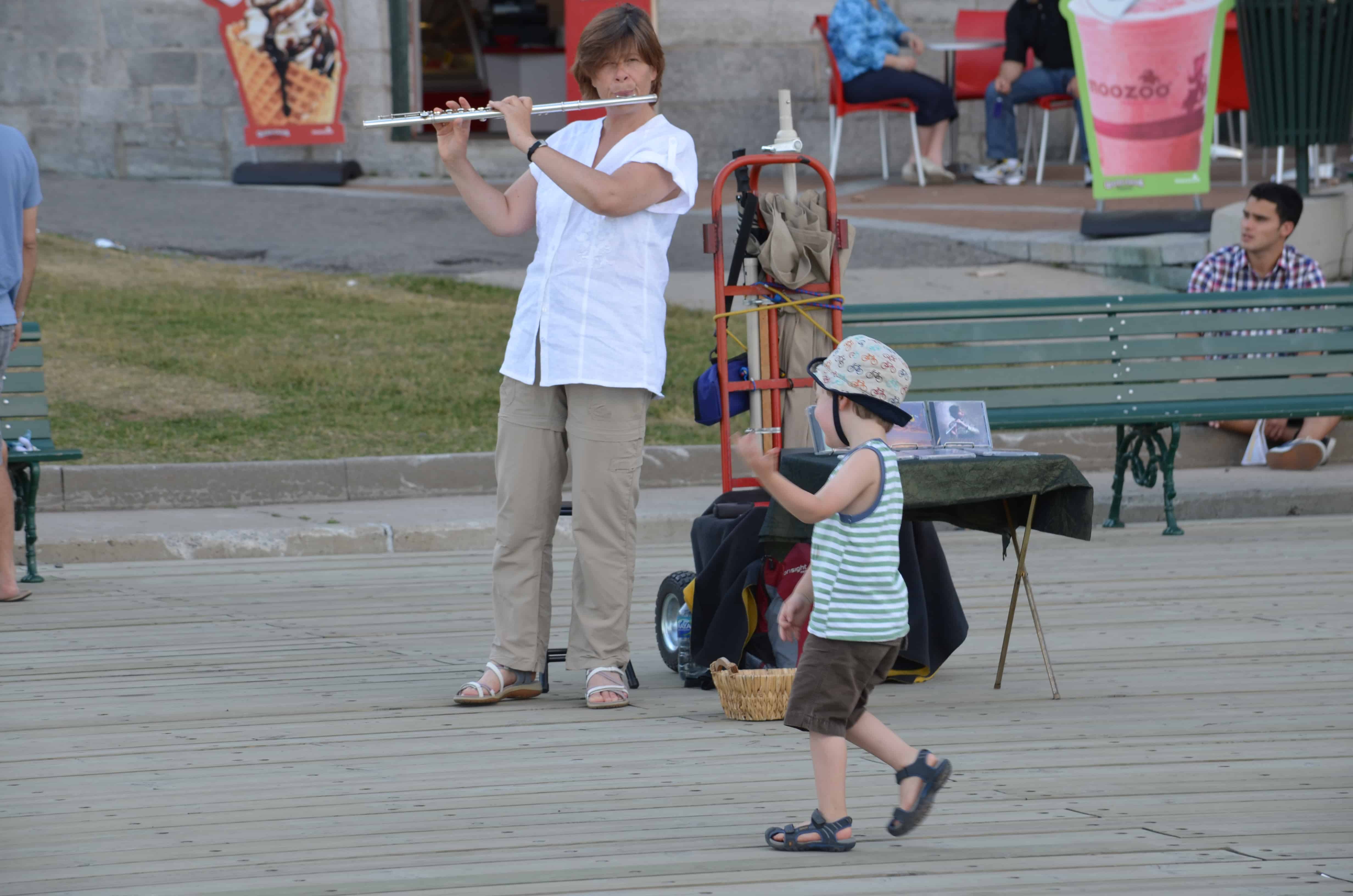 A flutist with a little boy dancing