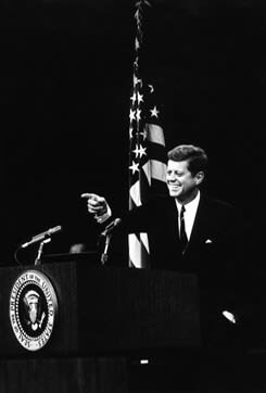 JFK at a press podium