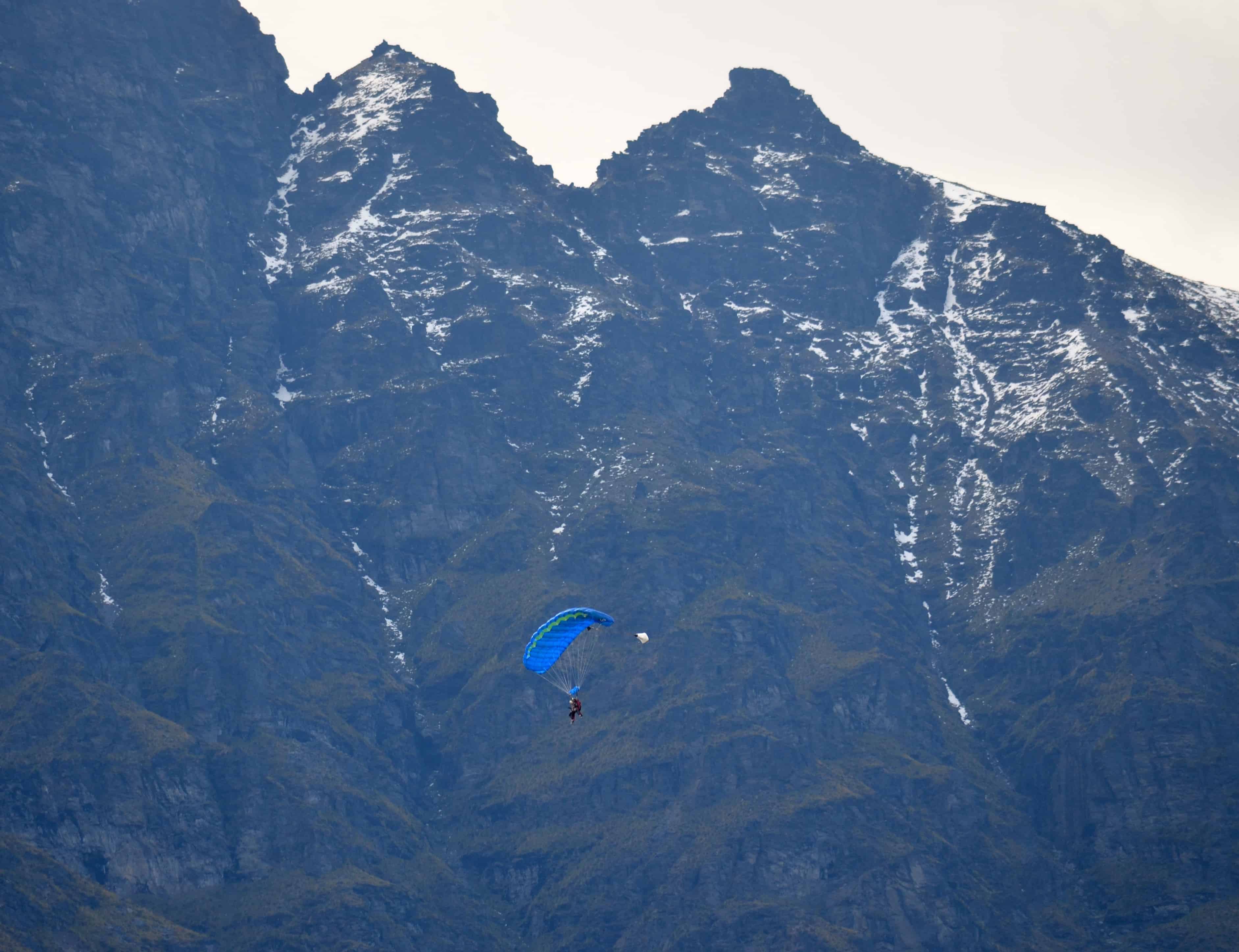 Skydivers descending in front of the Remarkables