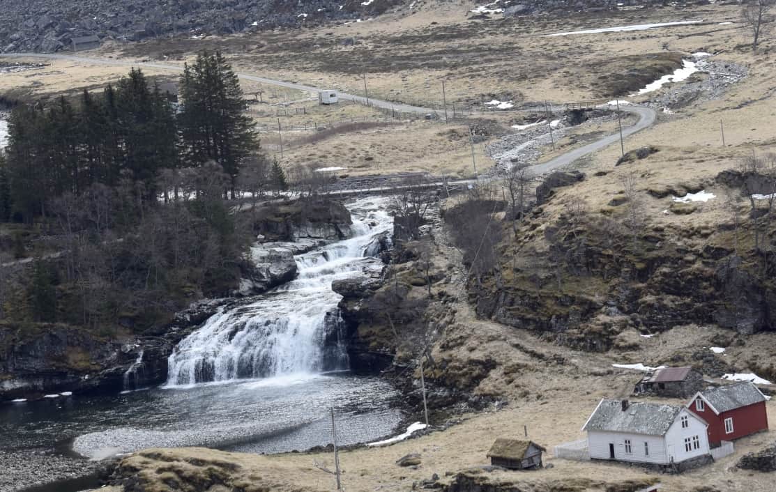 A farm, lake and waterfall seen from the Flam Railway