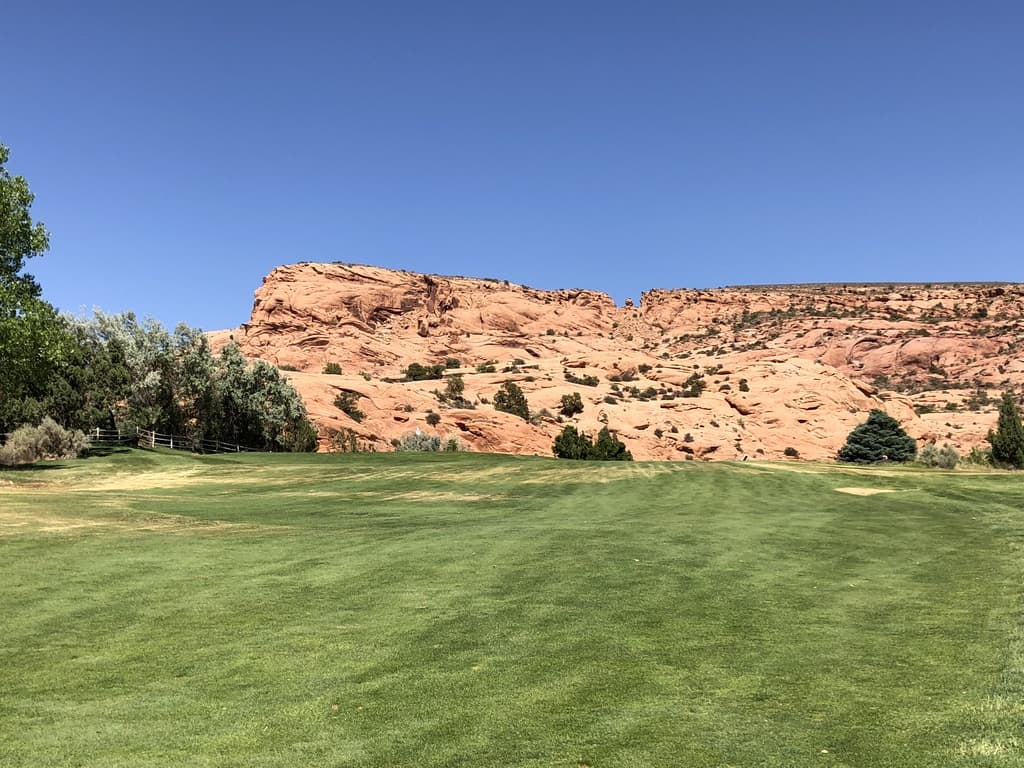 The Moab golf course with red rock cliffs all around